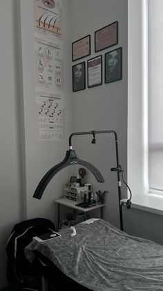 a bedroom with a bed, lamp and pictures on the wall above it in black and white