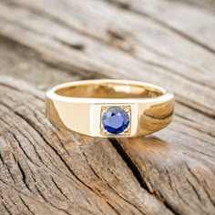 Product Details Ring Style: A custom, handcrafted men's wedding ring featuring a 14K gold band with a natural blue sapphire. Many other center stone options are available upon request. Center Stone: 5mm Round Natural Blue Sapphire Customizable: Because each ring is handcrafted to order, we can customize yours using unique materials, gemstones, or design features, often without any added cost! We can even use personal materials that you send! Basic customizations (material swaps, etc…) can be acc 14k Sapphire Promise Ring, Yellow Gold Sapphire Signet Ring With Polished Finish, Heirloom Style Polished Sapphire Ring, Sapphire Signet Ring With Polished Finish, Sapphire Signet Ring With Polished Finish For Promise, Yellow Gold Sapphire Ring With Tension Setting, Yellow Gold Sapphire Signet Promise Ring, 14k Gold Sapphire Signet Ring For Anniversary, Sapphire Ring Stamped 14k As Gift