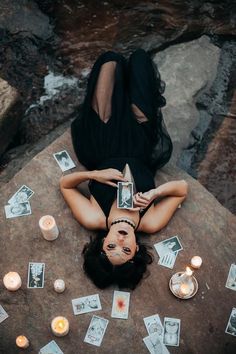 a woman laying on the ground surrounded by cards and candles