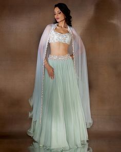 Mint gathered flowy lehenga with a white gold & pearl hand embellished waist band & blouse, paired with a net dupatta featuring an organza ruffle, embellished with ivory pearl drops & glass bugles.From Shloka Khialani's Winter Sun collection.DELIVERY TIMEPlease allow 6-8 weeks for your outfit to arrive.FABRIC DETAILSGeorgette, Net, Organza, CrepeProfessional cleaning only. Hand Embellished Georgette Palazzo Set For Wedding, Wedding Hand Embellished Georgette Palazzo Set, Anarkali Style Hand Embellished Palazzo Set For Wedding, Wedding Embellished Organza Palazzo Set, Fitted Hand Embellished Organza Lehenga, Hand Embellished Fitted Organza Lehenga, Hand Embellished Anarkali Organza Sets, Hand Embellished Palazzo Set For Wedding With Traditional Drape, Fitted Pre-draped Saree With Gota Work For Wedding