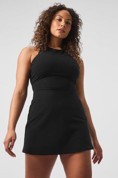 It’s a fresh ’90s spin on your favorite tennis dress, complete with a high neck, a fitted waist, and a short, swingy hem. But that’s not even the best part—see the open back and the chic trio of straps? Practical details include a built-in shelf bra with removable cups and built-in shorts with pockets for holding a tennis ball or two. Add some sneakers and get ready to serve. Black Fitted Athleisure Dress, Black Mini Length Tennis Dress In Athleisure Style, Black Mini Length Athleisure Tennis Dress, Black Athleisure Mini Length Tennis Dress, Chic Stretch Dresses For Workout, Black Athleisure Mini Tennis Dress, Black Stretch Mini Tennis Dress, Chic Stretch Workout Dress, Chic Sleeveless Workout Dress