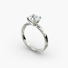 a white gold engagement ring with a single diamond in the center, on a white background