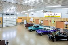 several classic cars are parked in a garage