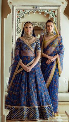 two women in blue dresses standing next to each other