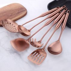 the kitchen utensils are lined up next to each other on a marble countertop