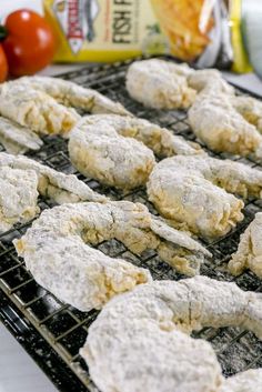 several cookies are cooling on a grill with tomatoes in the background