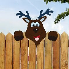 a wooden fence with a paper cut out of a reindeer's head on it