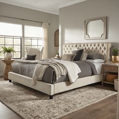 a large bed sitting in a bedroom on top of a wooden floor next to a window