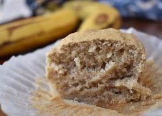 a close up of a banana muffin on a paper plate with bananas in the background