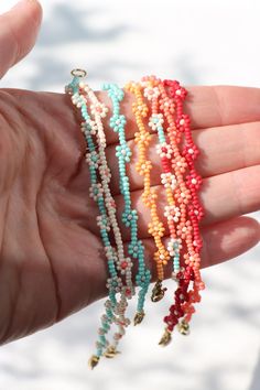 a hand holding several bracelets in different colors