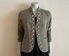 "Vintage Jacket Marching Band Jacket Khaki Women Blazer Cotton Jersey Long Sleeve Women's Jacket  Measurements (lying flat): Length: 25.5\"/ 65 cm Shoulder: 15\"/ 38 cm Pit to pit: 19.5\"/ 49.5 cm Waist: 17 1/4\"/ 44 cm Sleeve: 24.5\"/ 62 cm Please check measurements to insure a proper fit. Remember to allow yourself some extra room for movement. You can compare these with something from your closet that fits you well. Condition: Great Vintage Condition N.B. Color may slightly differ from picture SHIPPING * I ship worldwide via Priority mail * Items are shipped 1 - 3 business days after receiving the payment. * I ship from Europe, so please allow 2 to 3 weeks for the package to arrive if you live overseas. * Europe 5 - 10 business days. PAK 35 PRO" Spring Military Style Khaki Blazer, Military Style Khaki Blazer For Spring, Spring Military Style Workwear Blazer, Spring Military Blazer With Buttons, Fitted Military Outerwear With Buttons, Fitted Military Outerwear With Snap Buttons, Fitted Khaki Blazer With Buttons, Women Waistcoat, Green Jacket Women