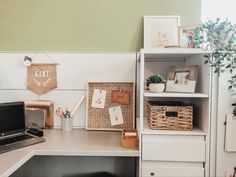 a desk with a laptop computer on top of it next to some baskets and plants