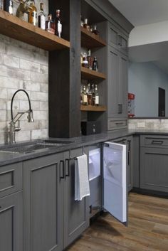 a kitchen with gray cabinets and wooden floors