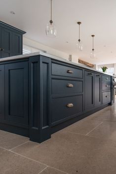 a large kitchen with blue cabinets and marble flooring