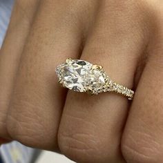 a close up of a person's hand with a diamond ring on their finger