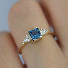 a woman's hand with a blue and white diamond ring