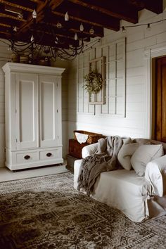 a bedroom with a bed, dresser and rug in front of white walls on the ceiling