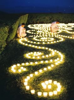 two people sitting on the ground with candles in the shape of a heart and an i love you sign