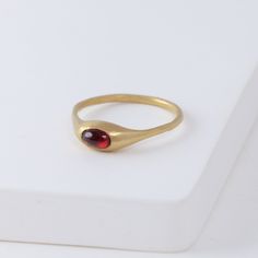 Description Hand-carved 14K yellow gold ring with a natural red garnet. Yui Ring embraces a graceful smoothness. She was made exactly for the Golden Hours - she’s confident, intelligent, poise and just entirely marvelous on her own. Not too loud, it shines just the right amount. Inspired by the nature, occasionally sweet pieces are often in organic shapes. The garnet gives a one-of-a-kind vivid red color to each ring. Details 14k Yellow GoldRed garnet - Approximately 2 x 3mm Made in U.S. *Please Red And Gold Ring, French Style Outfits, Ruby Ring Designs, Handmade Gold Ring, Classic French Style, Ring Inspo, Too Loud, Nice Jewelry, Golden Ring