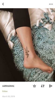 a woman's foot with a cross tattoo on it