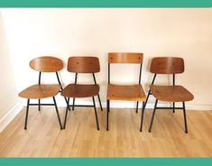 four wooden chairs are lined up against a wall in a room with hard wood flooring