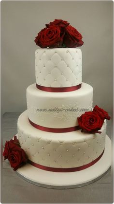 three tiered wedding cake with red roses on top