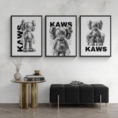 two black and white pictures hanging on the wall above a coffee table in a living room