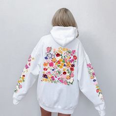 Elevate your style with this delightful and vibrant hoodie featuring a stunning wildflower design on the back and sleeves. Each hooded sweatshirt is carefully crafted to infuse a touch of nature into your wardrobe. The colorful wildflowers burst with life, creating a sense of warmth and joy. This hoodie is a perfect blend of style and comfort, making it an ideal addition to your wardrobe. Whether you're going for a walk in the park, a cozy evening in, or simply want to express your love for wildflowers, this hoodie has got you covered. Treat yourself or surprise a nature enthusiast in your life with this beautiful hooded sweatshirt. Don't wait - embrace the wildflower beauty today! 🌸 ✔️ Unique and eye-catching wildflower design ✔️ Soft and comfortable fabric for all-day coziness ✔️ Availa Spring White Hooded Sweatshirt, White Hooded Spring Sweatshirt, White Hooded Sweatshirt For Spring, Multicolor Spring Hoodie With Drawstring Hood, Multicolor Hoodie With Drawstring For Spring, White Casual Hoodie With Floral Print, Winter Floral Print Cotton Hoodie, Long Sleeve Floral Print Hoodie For Fall, Casual Hooded Sweatshirt With Floral Print