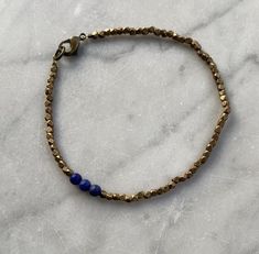 Lapis Lazuli and Faceted Brass Beaded Bracelet. Three 4 mm round lapis lazuli beads with 2-2.5 mm diamond cut faceted brass beads make up this bracelet, which closes with a lobster claw clasp. Also available in silver.I welcome custom orders! I can make this bracelet with other semi precious stones and silver or brass beads. The third photo shows other bracket options that are currently available.Arrives in a gift box. Brass Beaded Bracelets With Round Beads, Hand-strung Brass Bracelets With Round Beads, Brass Bracelets With Round Gold Beads, Adjustable Lapis Lazuli Beaded Bracelet With Faceted Beads, Gold Lapis Lazuli Beaded Bracelets With Round Beads, Gold Beaded Lapis Lazuli Bracelets, Bracelets Hippie, Silver Beaded Bracelet, Hippie Bracelets