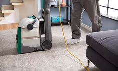 a man is using a vacuum to clean the carpet