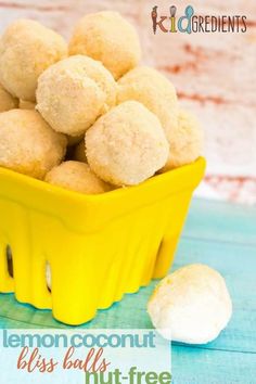 a yellow basket filled with lemon coconut bliss balls on top of a blue wooden table