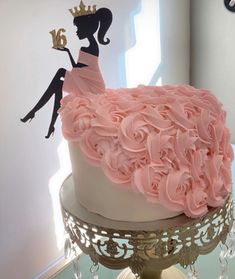 a cake decorated with pink frosting and a silhouette of a woman in a dress