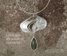 Lotus with tourmaline power – ￼ZEALmetalHandcrafted lotus and tourmaline pendant.  this piece has been hand pierced and carved from stainless steel with sterling silver accents, with a sterling silver bezel se large tear drop green tourmaline cab.   Green Tourmaline, also known as Verdelite, is perhaps Nature's best healing crystal of the physical heart, channeling its electrical energies into the center of one's being and creating a flow of wholesome energy to all parts of the body and self. Hand Piercing, Parts Of The Body, Tourmaline Pendant, Green Tourmaline, Silver Accents, Tear Drop, Healing Crystal