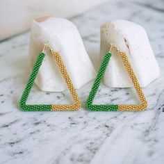 New for Summer 2023 from Narratives The Line. These beautiful Green & Beige Triangle Beaded Earrings are a fashionista's must-have. Crafted with precision and attention to detail, the dynamic combination of warm beige, vibrant green, and geometric shapes make these earrings a statement piece. Perfect for day or night. Dimensions: 7cm x 6cm.  Surgical Steel posts. Designed in London, made by our friends in India. Geometric Seed Bead Earrings, Geometric Beaded Gold Earrings, Beaded Earrings Triangle, Adjustable Triangle Beaded Earrings, Handmade Green Triangle Earrings, Geometric Lines, Jewelry Earrings Hoops, Geometric Shapes, Beaded Earrings