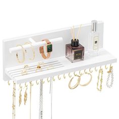 a white shelf with jewelry hanging from it's sides