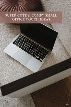 an open laptop computer sitting on top of a white couch next to a brown pillow