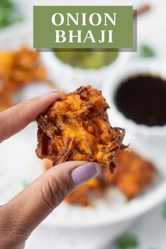 someone holding up some food in their hand with the words onion bhaji above it