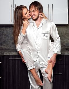 a man and woman in white pajamas posing for a photo with their heads close to each other