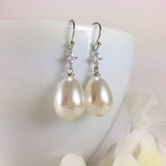 "Pearl Earrings, Gold Pearl Earrings, Simple Pearl Earrings, Pearl Dangle Earrings, Long Dangle Earrings, Minimal Earrings, Pearl Teardrop Earrings, CZ Pearl Earrings, Wedding Bridal Earrings, Bridesmaid Gift, Pearl Jewelry, Gift for Her Minimal classic design, these lovely earrings are composed of a large 21x13mm faux teardrop pearl dangling from a small diamond shaped CZ accent stone and simply hung from gold plated ear wires. Dangle length is 1-1/2\" (40mm) from the top of ear wire. Discount Pearl Earrings Simple, Simple Pearl Earrings, Earrings Gold Pearl, Pearl Teardrop Earrings, Pearl Earrings Gold, Evil Eye Necklace Gold, Earrings Minimal, Simple Pearl, Minimal Earrings