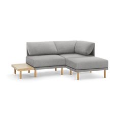 a gray couch with wooden legs and a small table on the floor next to it