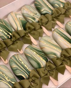 green and gold decorated cookies in a box with bows on the top are ready to be eaten