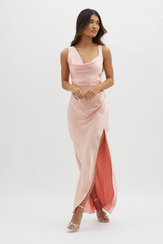 a woman is wearing a pink dress with an asymmetrical slit down the side