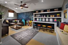 a living room filled with furniture and a chalkboard wall