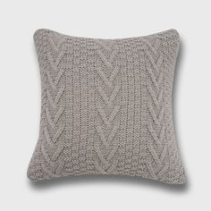 a gray knitted pillow on a white background