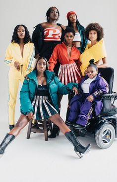 a group of women in colorful outfits posing for a photo with one woman on a wheel chair