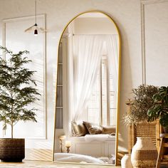 a large mirror sitting on top of a table next to a potted plant