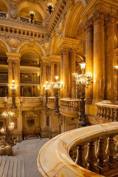 the inside of a building with chandeliers and marble steps leading up to it