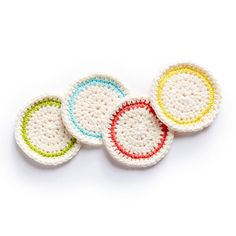 four crocheted coasters in different colors