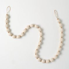 a white beaded necklace on a white background