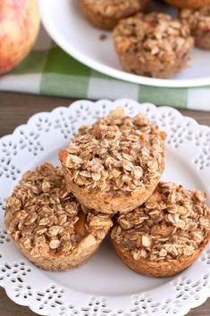 three muffins on a plate with apples in the background